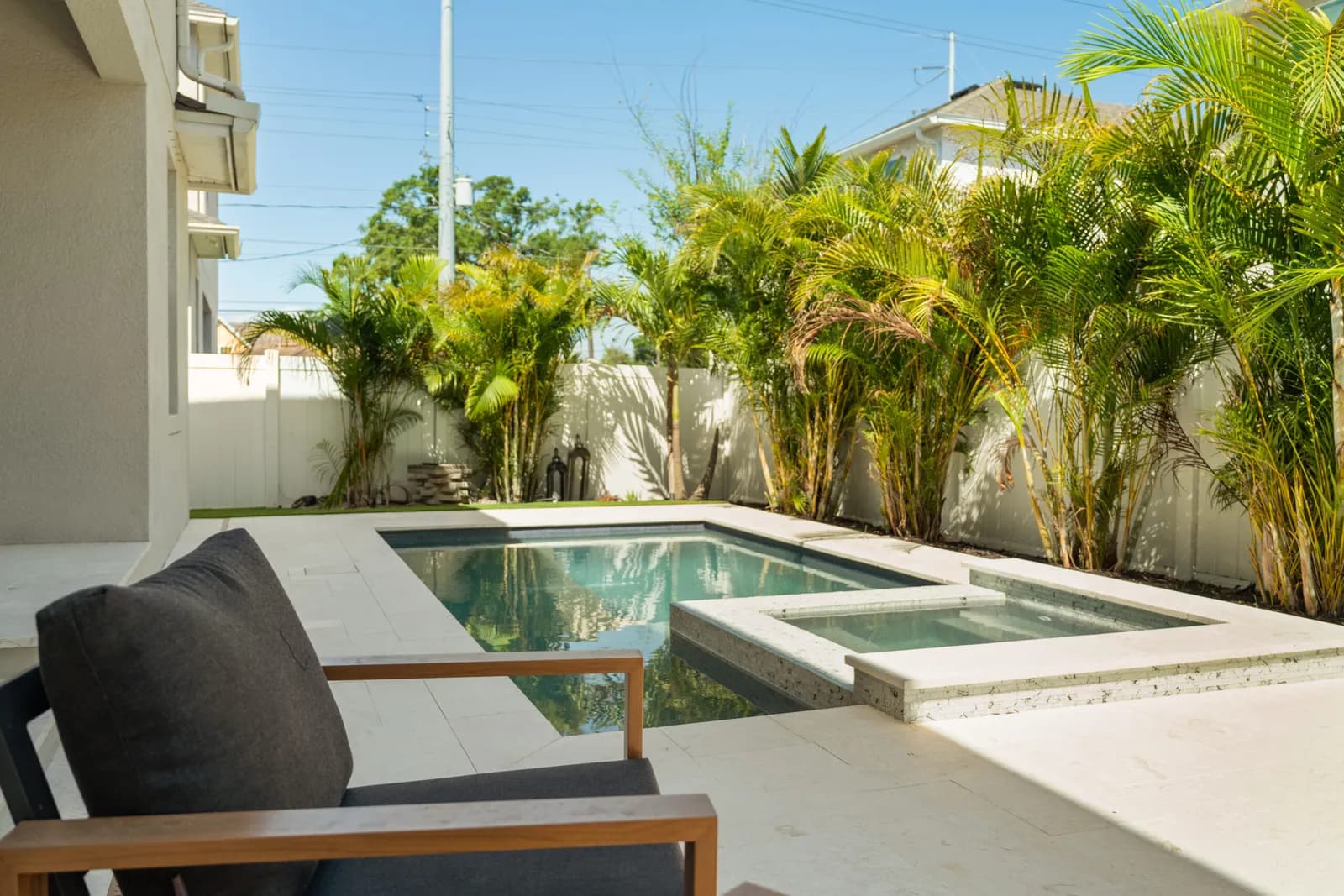 Travertine paver pool deck with a spa and tropical landscaping on a Tampa Bay backyard built by LIV Pools