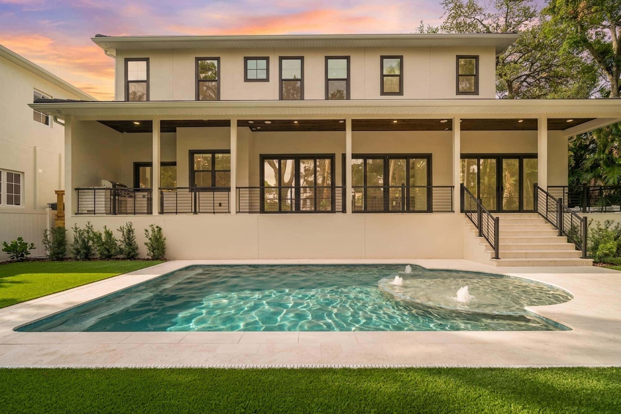 LIV Pools custom pool with sun shelf bubblers behind a modern Tampa Bay home