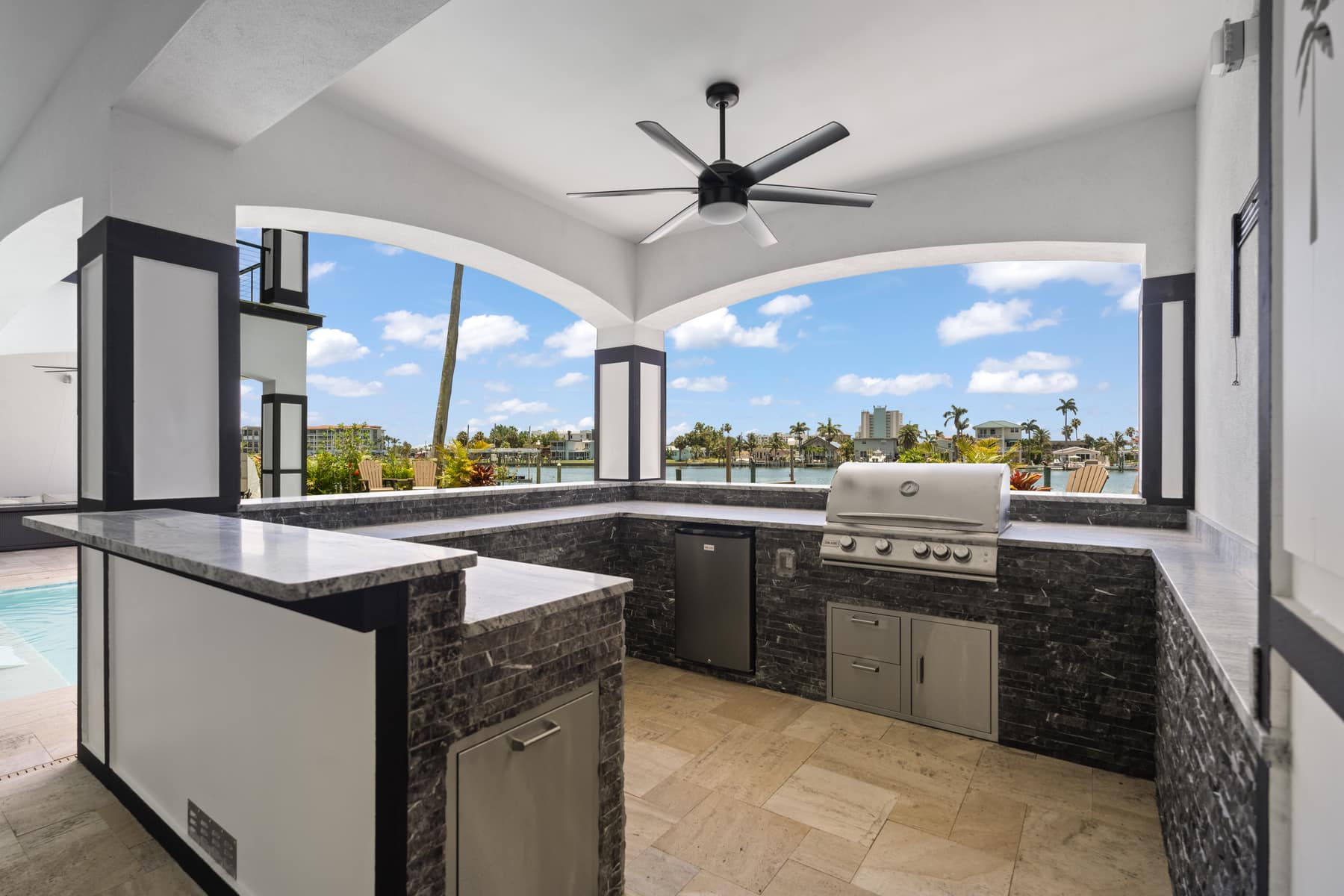 A waterfront outdoor kitchen and pool terrace on Tampa Bay, built by LIV Pools